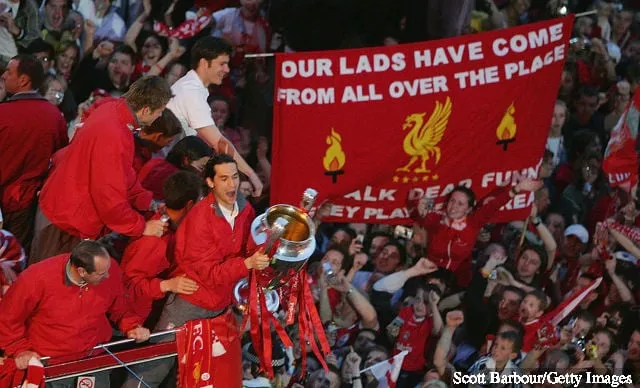 リバプールチームがセントジョージ到着時に大勢のファンの間をオープントップバスに乗り、トロフィーを掲げるルイス・ガルシア' title='ルイス・ガルシア、レジェンド戦後にリバプールにツイッターメッセージを送る 一部のファンが反応