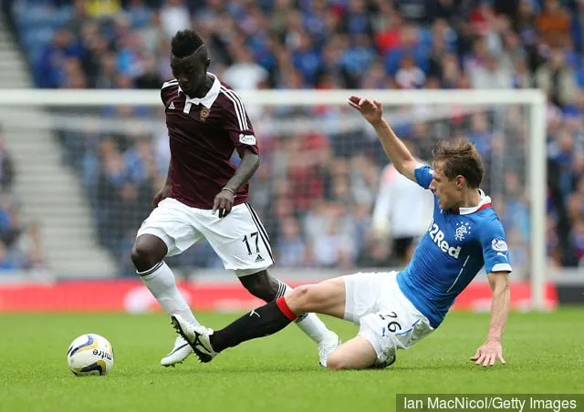 2014年8月10日、アイブロックス・スタジアムで行われたスコットランド・チャンピオンシップ開幕リーグのレンジャーズ対ハーツ戦で、ハーツのブアベン王子(左)がレンジャーズのマリウス・ザリューカスと対戦する。' title='アリー・マッコイストのレンジャーズとの最近の5つの契約: 彼らは今どこにいますか?