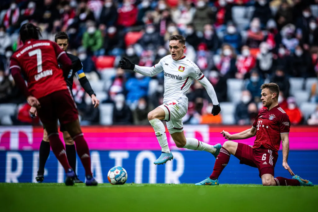 ミュンヘンドイツ - 3月5日: (編集者注: 画像はデジタル処理されています。)2022年3月5日にドイツ・ミュンヘンのアリアンツ・アレーナで行われたブンデスリーガのFCバイエルン・ミュンヘン対バイエル04レバークーゼンの試合で、ミュンヘンのヨシュア・キミッヒ(右)と対戦するレバークーゼンのフロリアン・ヴィルツ(C)。 (写真提供:Lukas Schulze/ブンデスリーガ/ブンデスリーガ コレクション、ゲッティイメージズ経由)' title='「スペシャル」:チームメイトがリヴァプール・トッテナムの目標額1億2500万ポンドを「非常に遠くまで」達成することを示唆