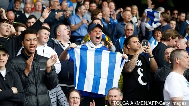 I tifosi del Brighton sventolano bandiere e cantano in mezzo alla folla durante la partita di calcio della Premier League inglese tra Crystal Palace e Brighton e Hove Albion al Selhurst Park, nel sud di Londra, il 27 agosto.' title='Clinton Morrison invia un messaggio su Twitter prima dello scontro di Crystal Palace a Brighton