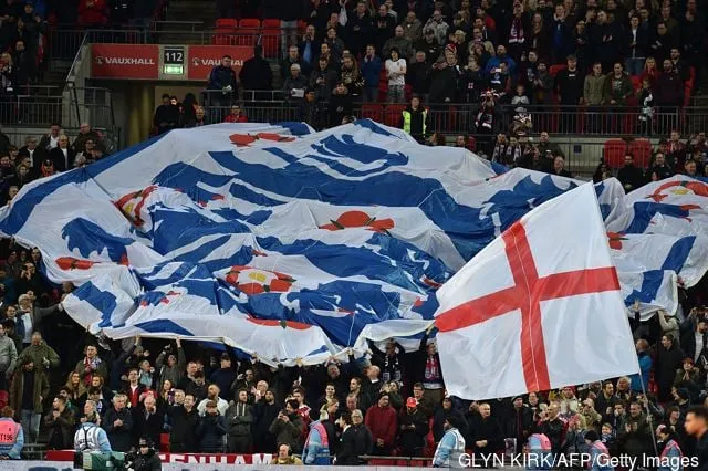 Англійскія заўзятары раскрываюць велізарны сцяг з трыма львамі ў натоўпе перад міжнародным таварыскім футбольным матчам паміж зборнымі Англіі і Італіі на стадыёне 'Уэмблі' ў Лондане 27 сакавіка 2018 года.' title='7 краін, якія найбольш захапляюцца футболам